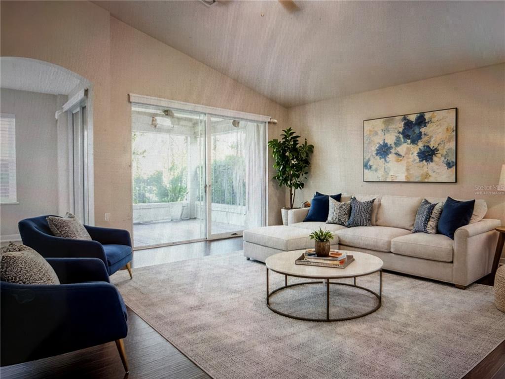 A living room features a sectional sofa, two blue armchairs, and a sliding glass door — 29636 TEE SHOT DRIVE, SAN ANTONIO, FL