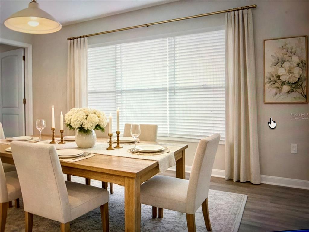 A dining room features a wooden table, upholstered chairs, and a large window with curtains — 29636 TEE SHOT DRIVE, SAN ANTONIO, FL