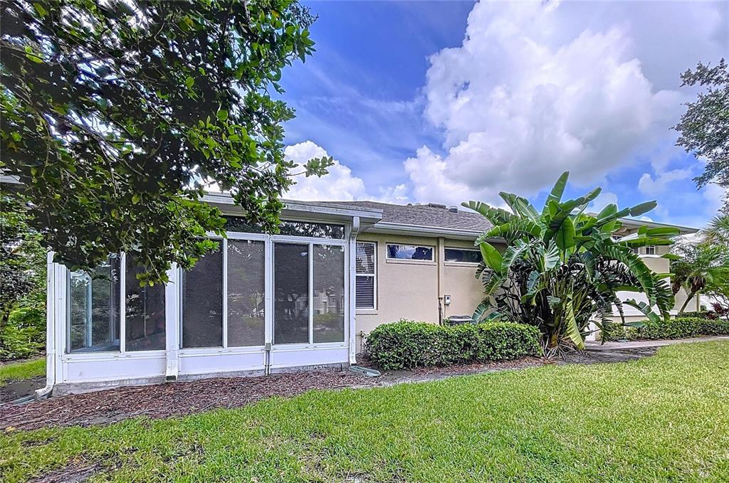 The exterior view shows a house with a screened-in porch and a large tropical plant — 2018 INVERNESS GREENS DRIVE UNIT 2018, SUN CITY CENTER, FL