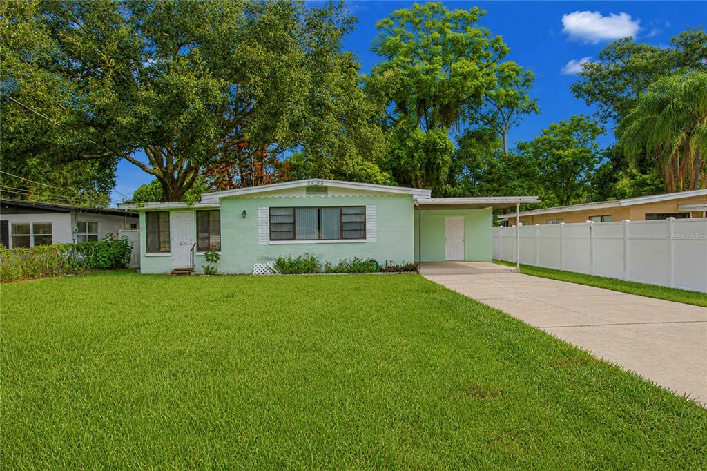 A light green, single-story house features a front lawn, a concrete driveway, and a carport — 4205 MIZELL STREET, ORLANDO, FL