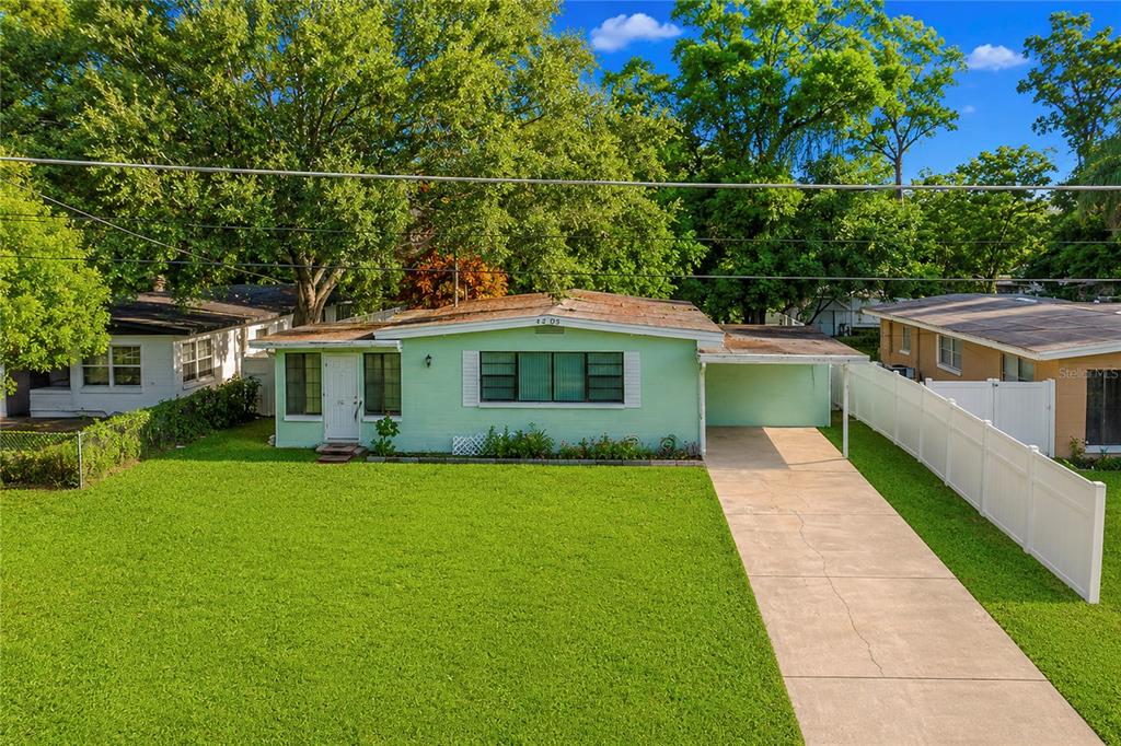 A light green single-story house with a concrete driveway and a large front lawn — 4205 MIZELL STREET, ORLANDO, FL