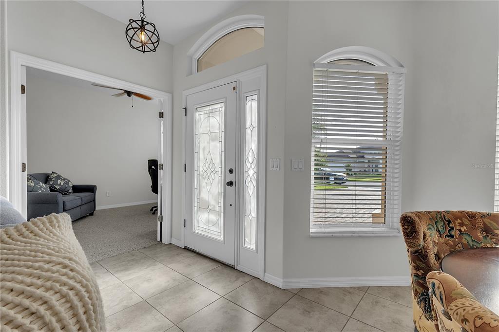 An entryway with tile flooring, a glass-paneled front door, and an adjacent office room — 113 ARENA LAKE DRIVE, PALM COAST, FL