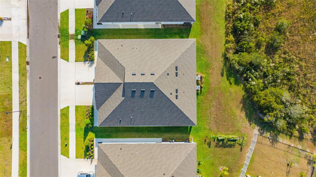 An aerial view shows a community clubhouse with two swimming pools surrounded by landscaping — 2555 BENDING BONSAI DRIVE, WESLEY CHAPEL, FL