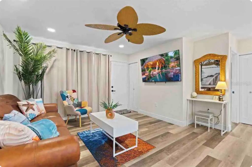 A living room features a brown leather sofa, a white coffee table, and a ceiling fan — 301 N HOLLYWOOD AVENUE, DAYTONA BEACH, FL