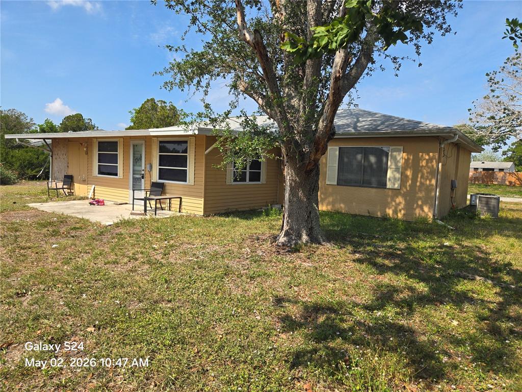A single-story yellow house with a large tree in the front yard — 3322 BOHIO STREET, NORTH PORT, FL
