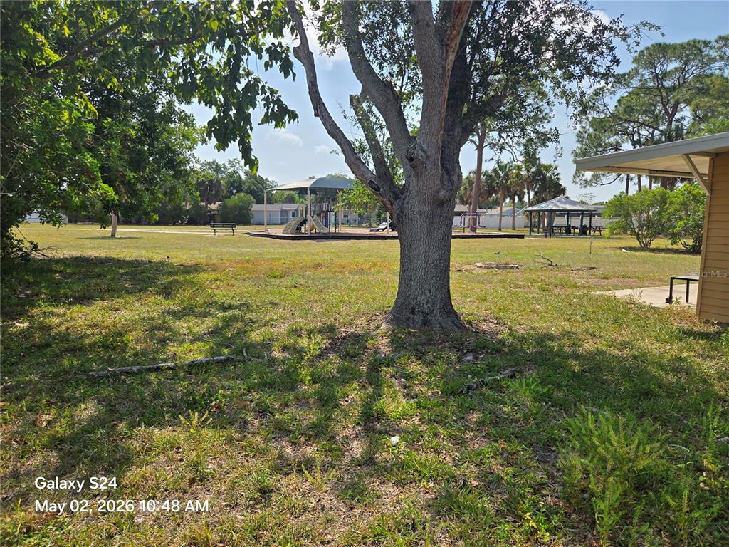A grassy park area features a large tree, a playground, and a covered pavilion — 3322 BOHIO STREET, NORTH PORT, FL