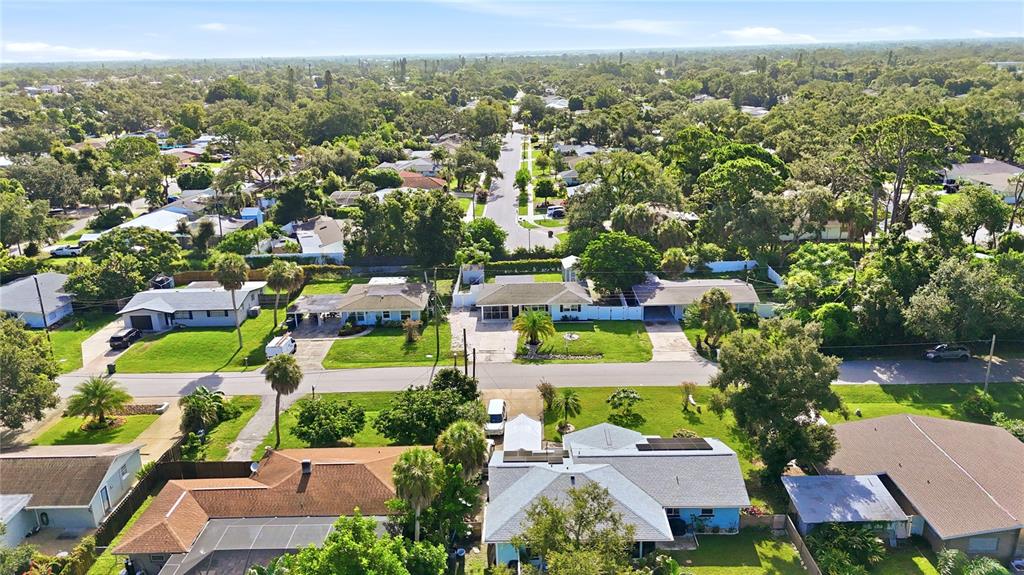 A kitchen with white cabinets, stainless steel appliances, and a small dining area with chairs — 6103 CARLTON AVENUE, SARASOTA, FL
