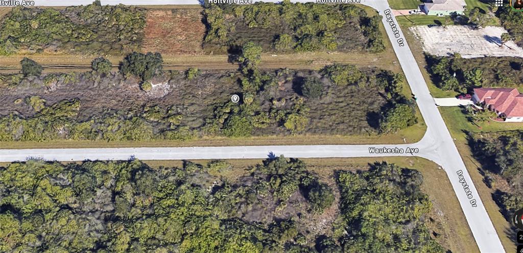 This is an aerial view of a vacant, wooded residential lot at a street intersection — 13336 WAUKESHA AVENUE, PORT CHARLOTTE, FL