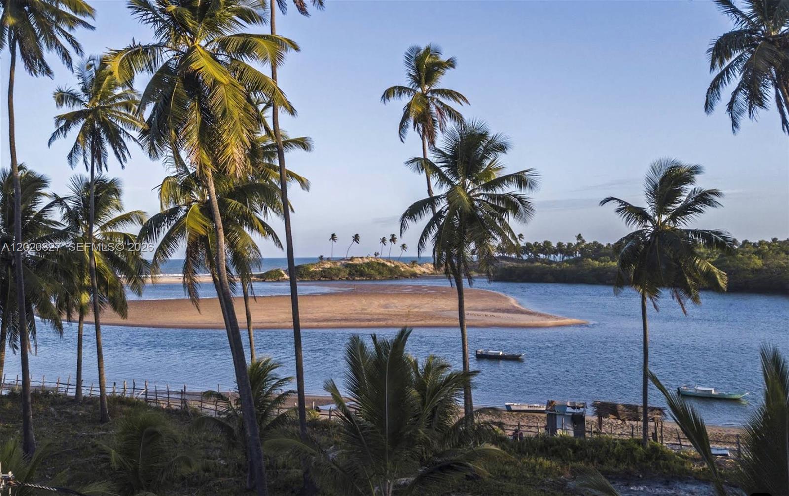 A scenic view of a tropical river meeting the ocean with palm trees and boats — 117 Praia Barra do Itariri Peninsula, FL, FL