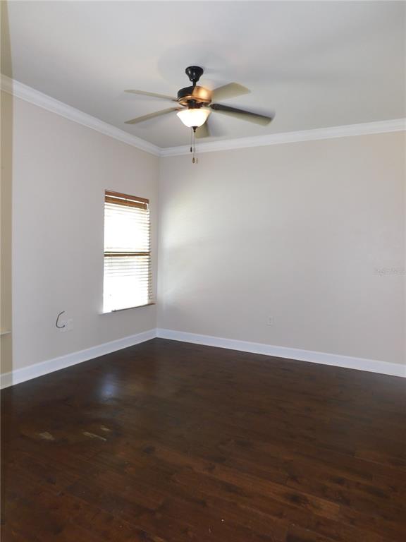 A living room features dark wood flooring, a ceiling fan, and a white front door — 5156 NW 21ST DRIVE, GAINESVILLE, FL