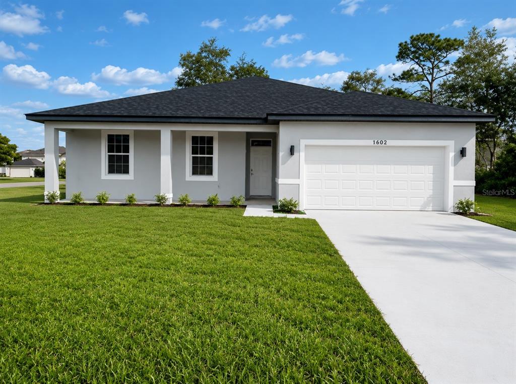 A single-story house with a gray exterior, a two-car garage, and a front porch — 1602 PICKEREL COURT, POINCIANA, FL