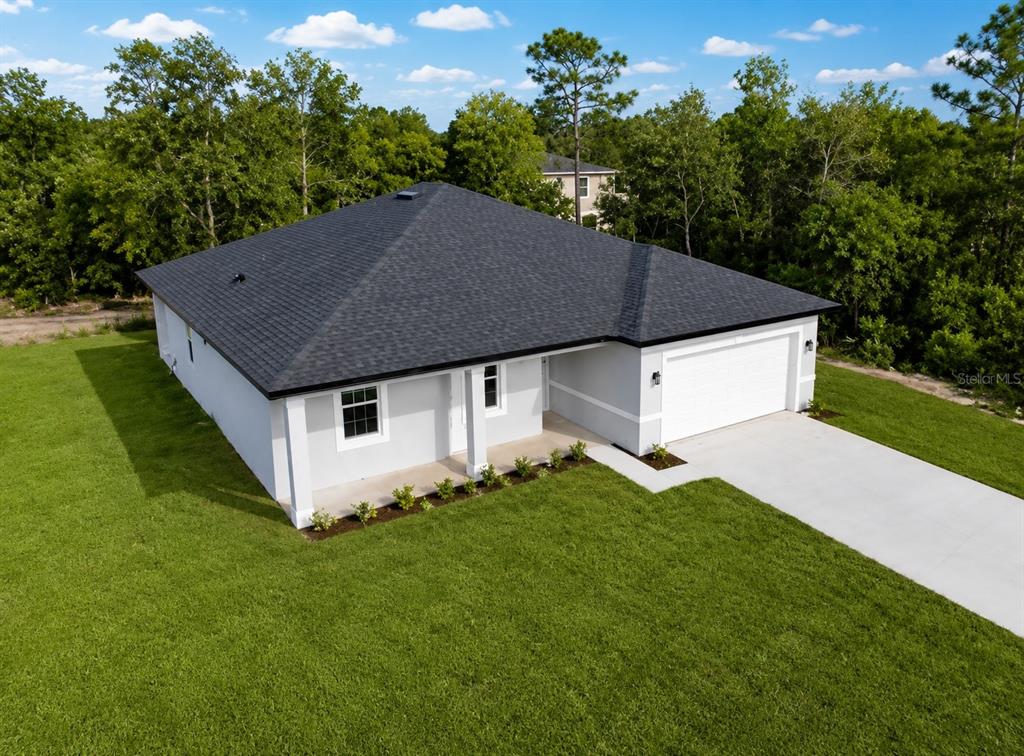 An aerial view of a single-story house with a gray exterior and a dark roof — 1602 PICKEREL COURT, POINCIANA, FL