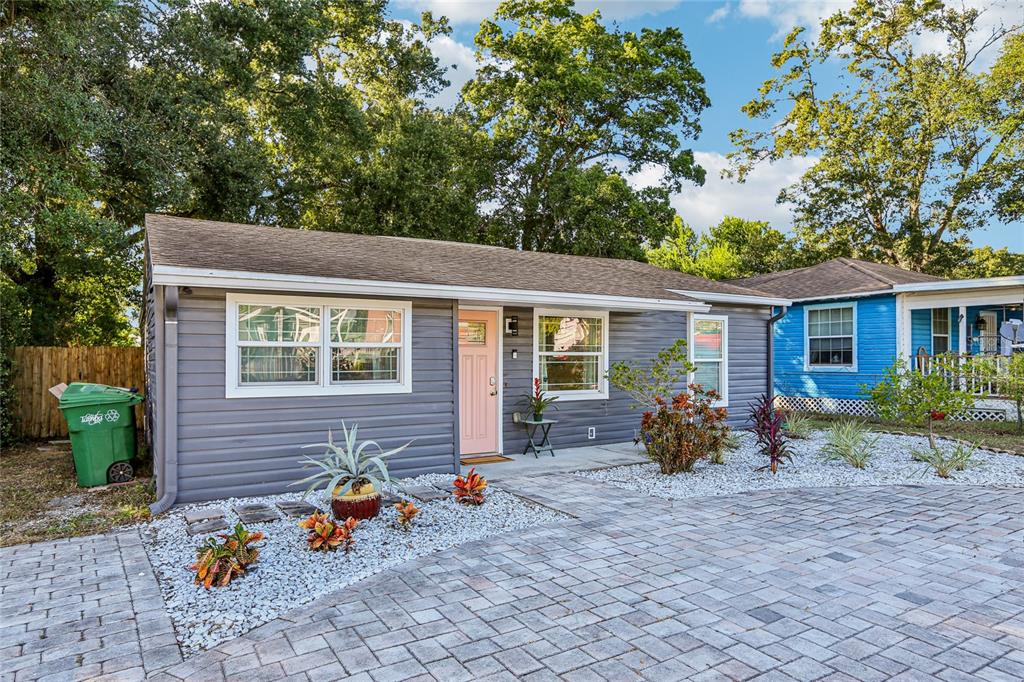 A gray-sided house with a pink front door and a paved driveway — 4104 N SEMINOLE AVENUE, TAMPA, FL