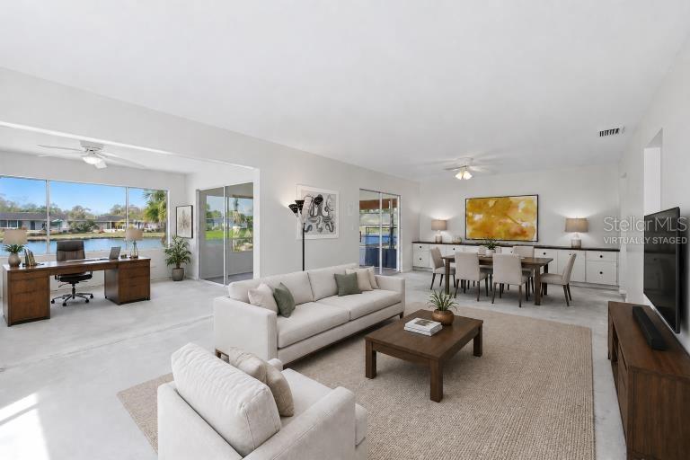 This open-concept living area features a home office, dining space, and views of water — 3960 LAKESIDE ROAD UNIT 156, SARASOTA, FL
