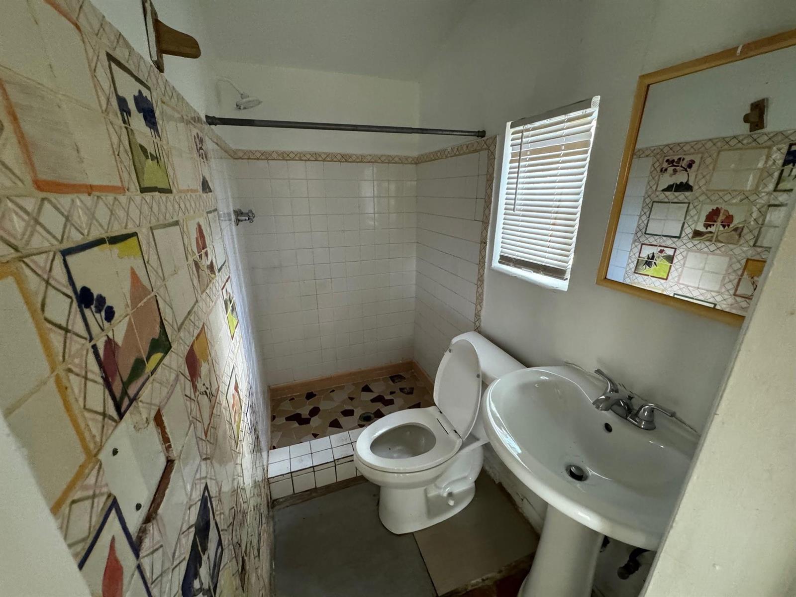 A small bathroom features a pedestal sink, a toilet, and a tiled walk-in shower — 8261 NW 1st Place # 3, Miami FL 33150, MIAMI, FL