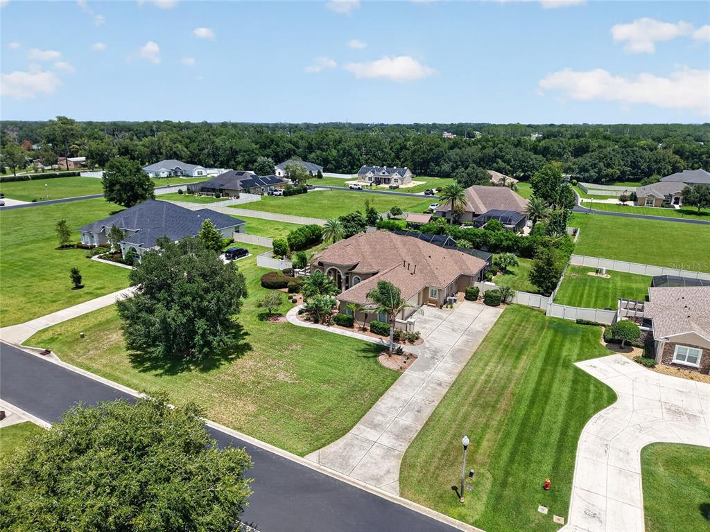 An aerial view shows a suburban neighborhood with several single-family homes and large grassy yards — 3986 SE 43RD CIRCLE, OCALA, FL