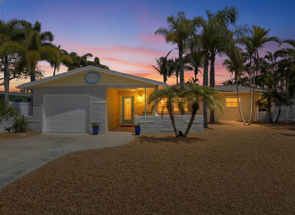A single-story house with a gravel yard, palm trees, and a light-colored brick facade — 3014 58TH STREET S, GULFPORT, FL