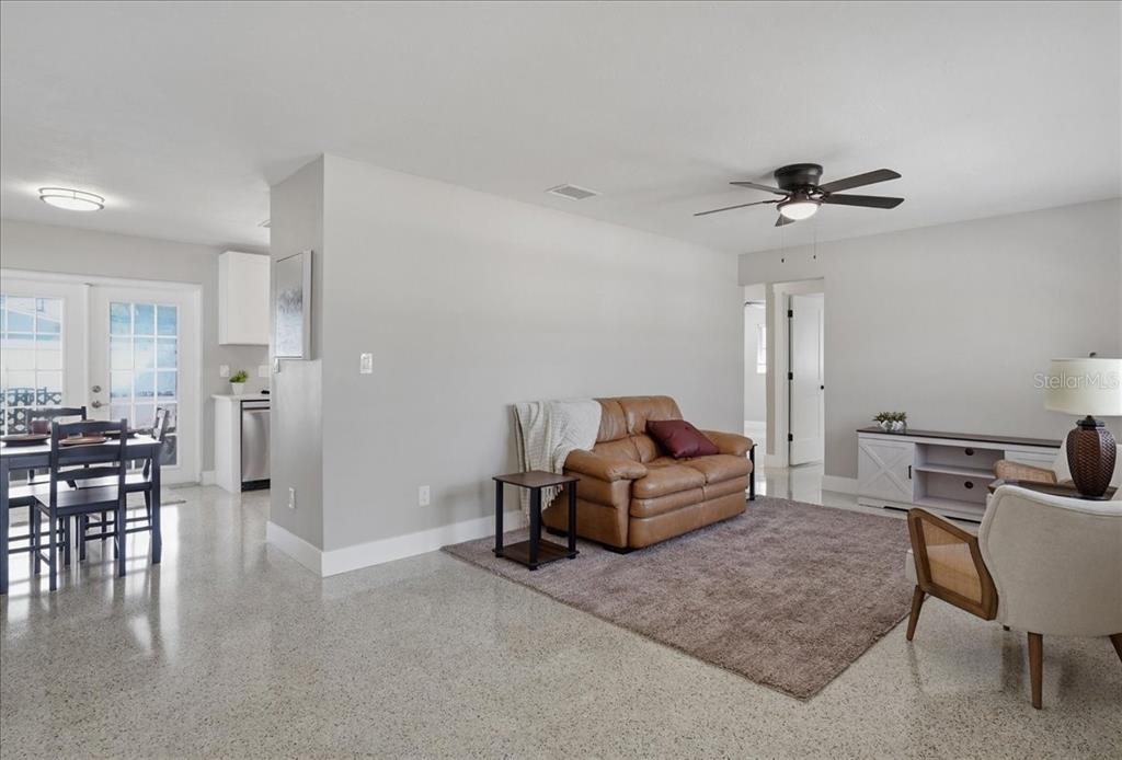 A living room with a brown leather sofa, area rug, and adjacent dining area — 3014 58TH STREET S, GULFPORT, FL