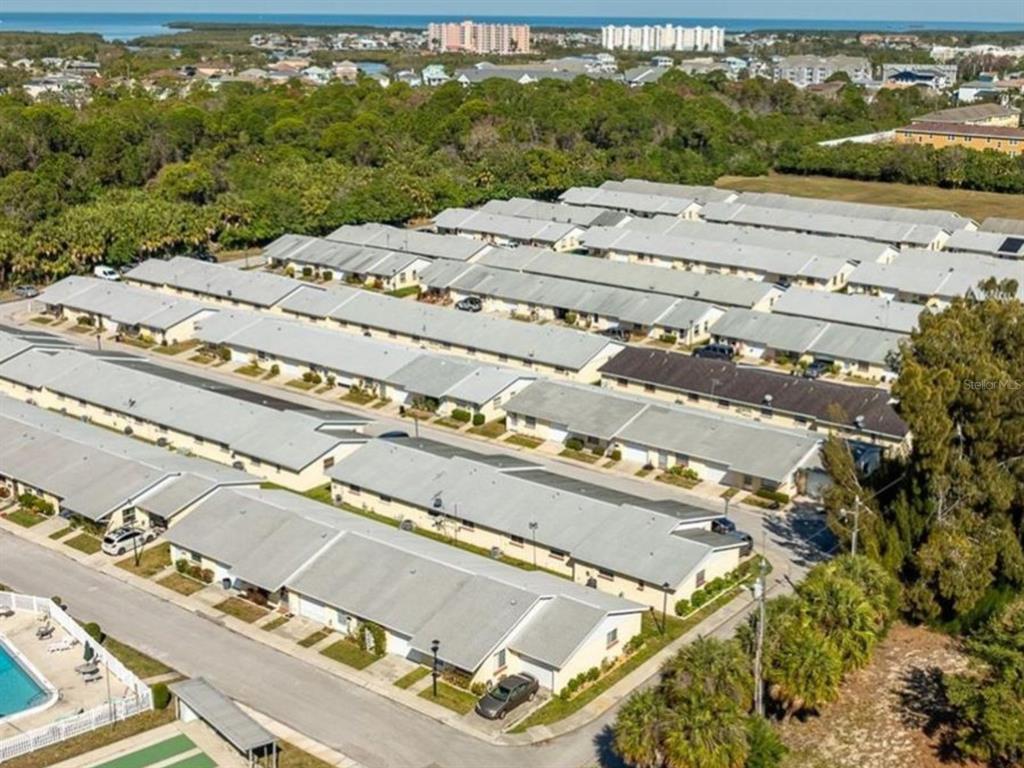 An aerial view shows rows of single-story residential townhomes with gray roofs and paved streets — 4954 BITNER STREET, NEW PORT RICHEY, FL