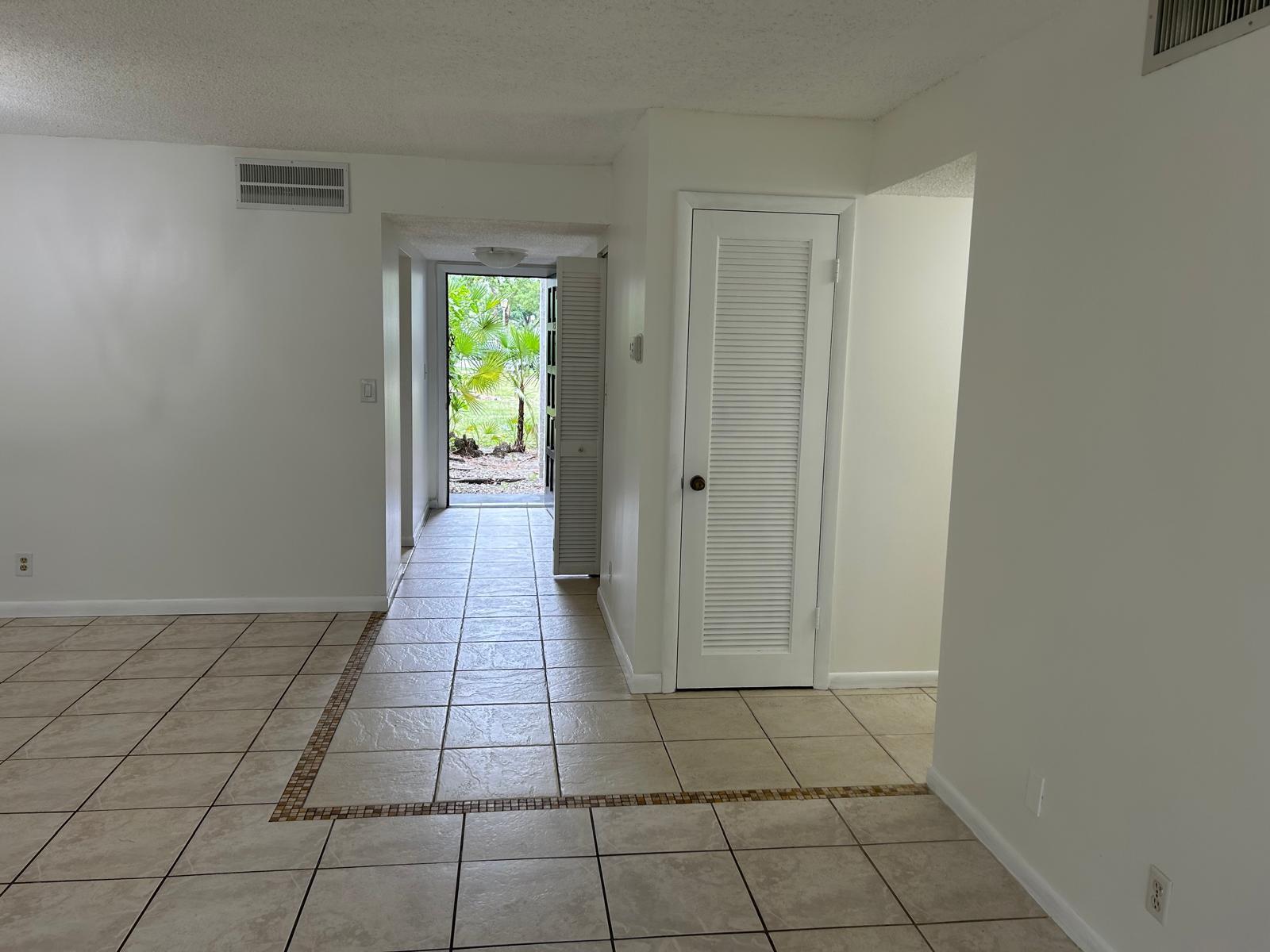 An interior view showing a tiled entryway leading to an open doorway with outdoor greenery — 3300 Spanish Moss Terrace, Lauderhill FL 33319, LAUDERHILL, FL