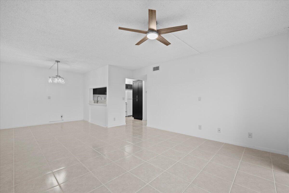An empty room with white walls, light tile flooring, and a ceiling fan — 708 Sunny Pine Way # B1, FL 33415, FL