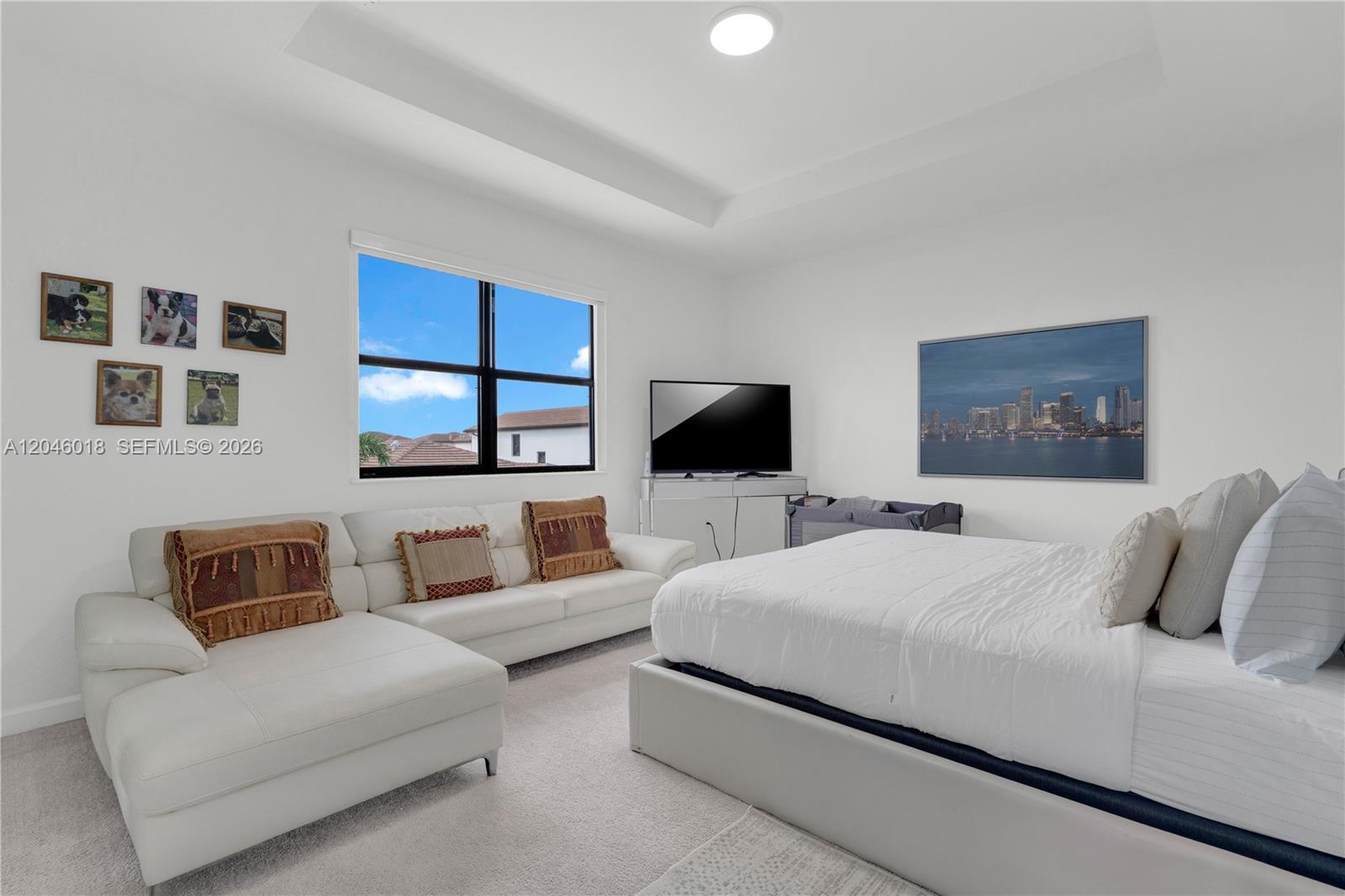 A bedroom features a white sectional sofa, a bed, a television, and framed pet photos — 12924 SW 229th St, Miami FL 33170, MIAMI, FL