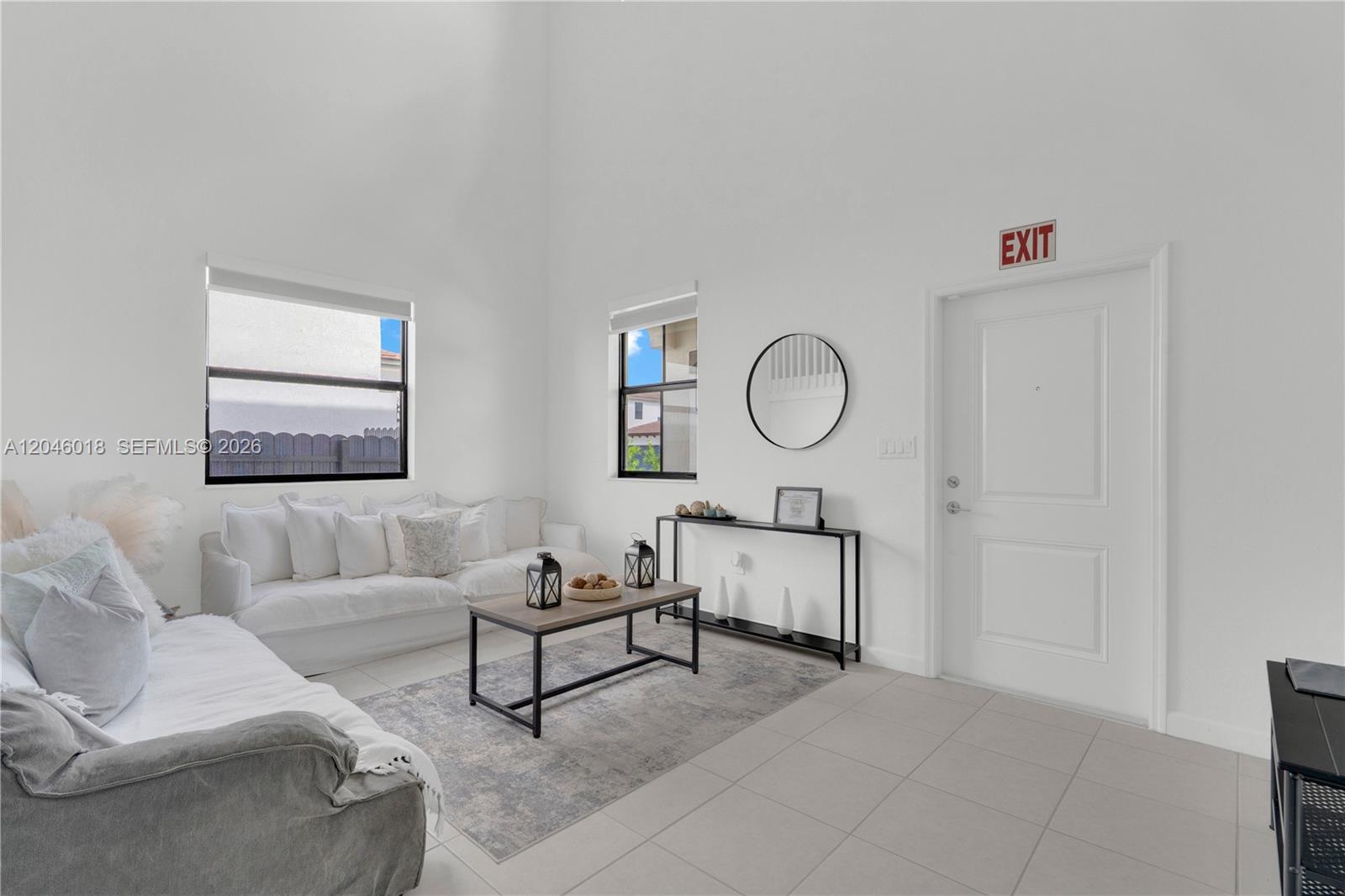 A bright living room features white walls, tile flooring, a sofa, and a coffee table — 12924 SW 229th St, Miami FL 33170, MIAMI, FL