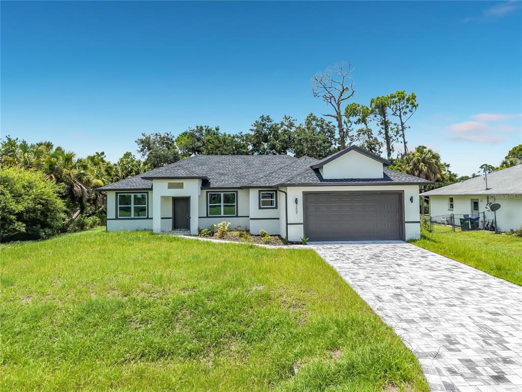 A single-story house with a white exterior, dark trim, and a paved driveway — 2607 SEAGULL LANE, NORTH PORT, FL