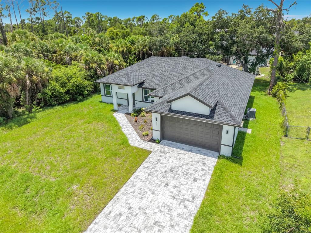 An aerial view of a single-story house with a paved driveway and a dark roof — 2607 SEAGULL LANE, NORTH PORT, FL