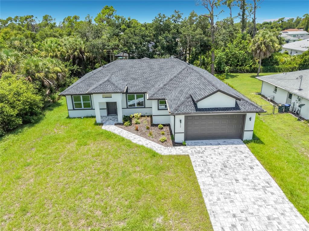 An aerial view of a single-story house with a dark roof and paver driveway — 2607 SEAGULL LANE, NORTH PORT, FL