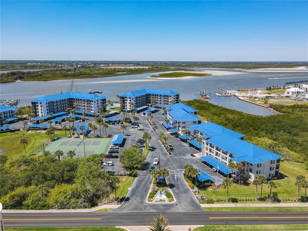A screened-in balcony features a ceiling fan, metal railings, and a view of greenery — 2700 N PENINSULA AVENUE UNIT 536, NEW SMYRNA BEACH, FL