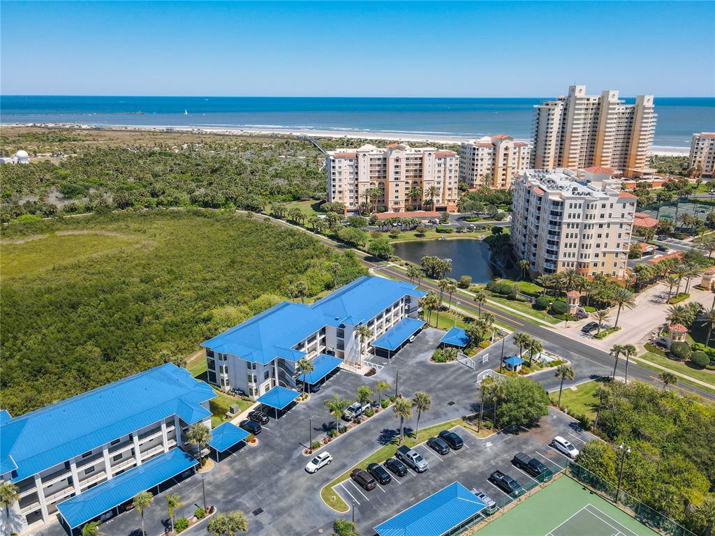 An aerial view shows a multi-story building with a blue metal roof and parking lot — 2700 N PENINSULA AVENUE UNIT 536, NEW SMYRNA BEACH, FL