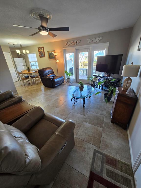 A living room with tile flooring, a ceiling fan, and a glass-topped coffee table — 5231 BEACH DRIVE SE UNIT A, ST PETERSBURG, FL