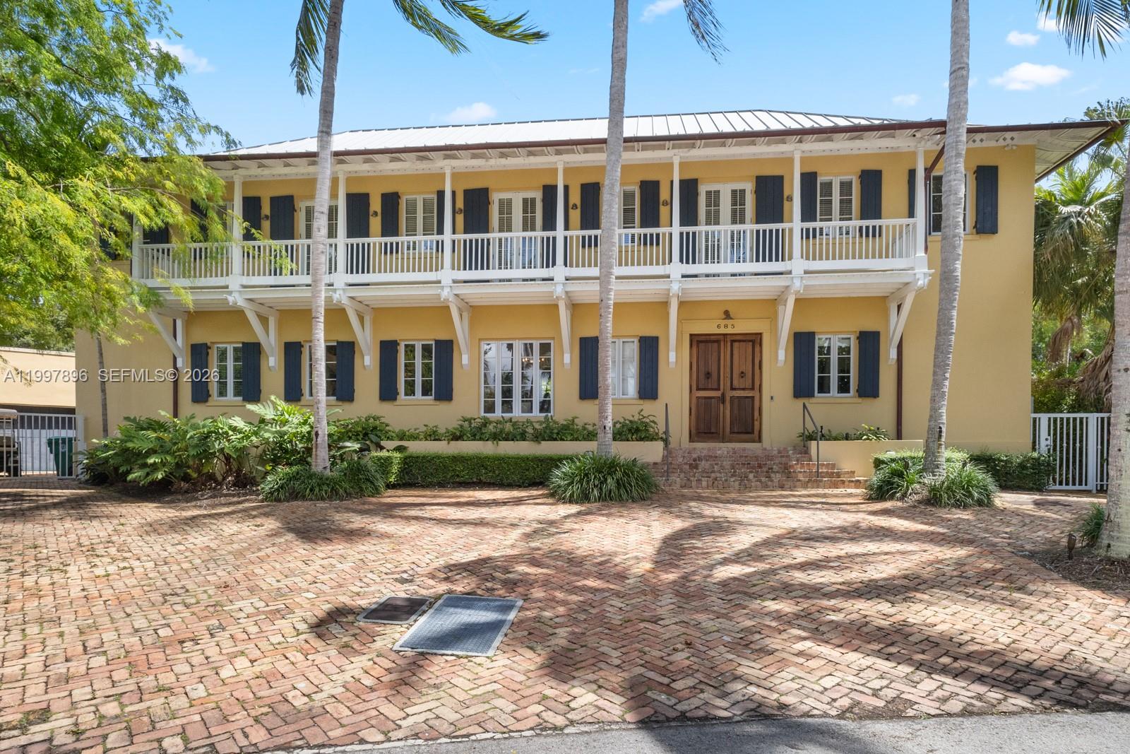 A two-story yellow house with a wrap-around balcony and a brick driveway — 685 Harbor Ln, Key Biscayne FL 33149, KEY BISCAYNE, FL