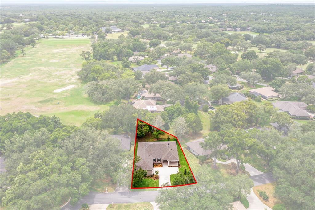 An aerial view shows a single-story house outlined in red within a wooded neighborhood — 3030 W BERMUDA DUNES DRIVE, LECANTO, FL