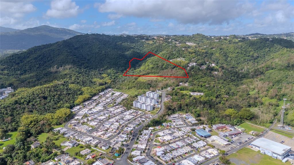 An aerial view shows a residential neighborhood with a red-outlined plot of undeveloped land — PR 7784 Km 1.0 TURABO, CAGUAS, PR