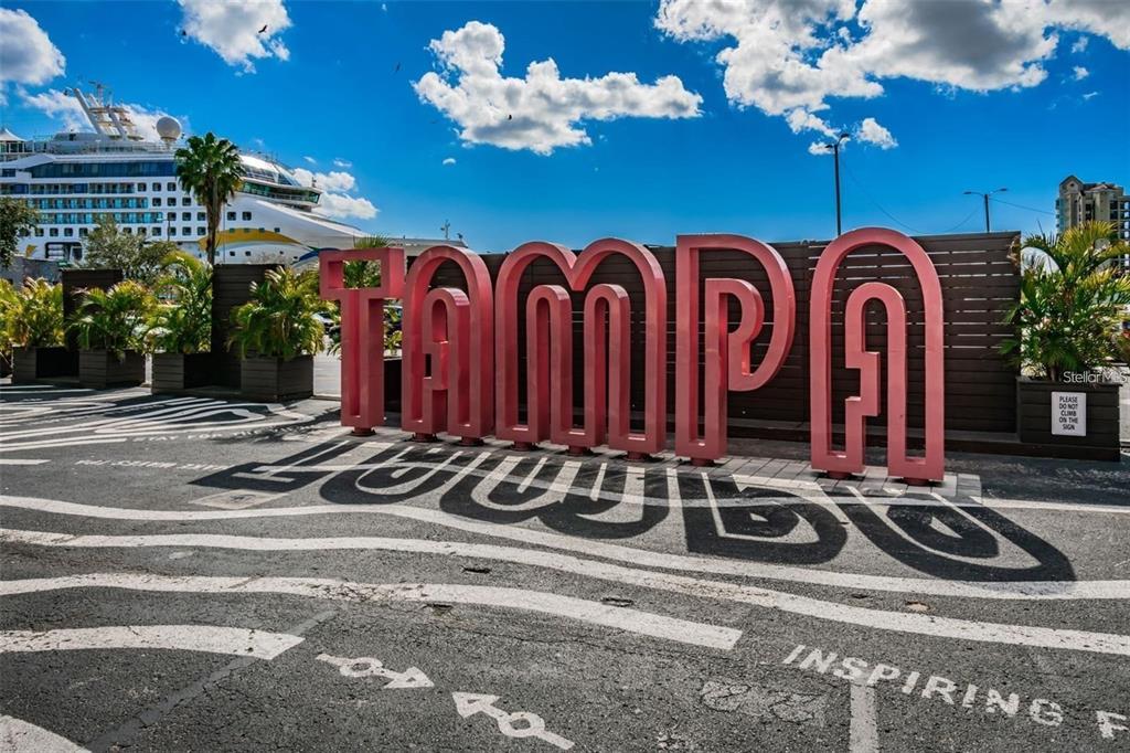 A large red TAMPA sign stands on a paved area near a cruise ship — 1209 E CUMBERLAND AVENUE UNIT 508, TAMPA, FL