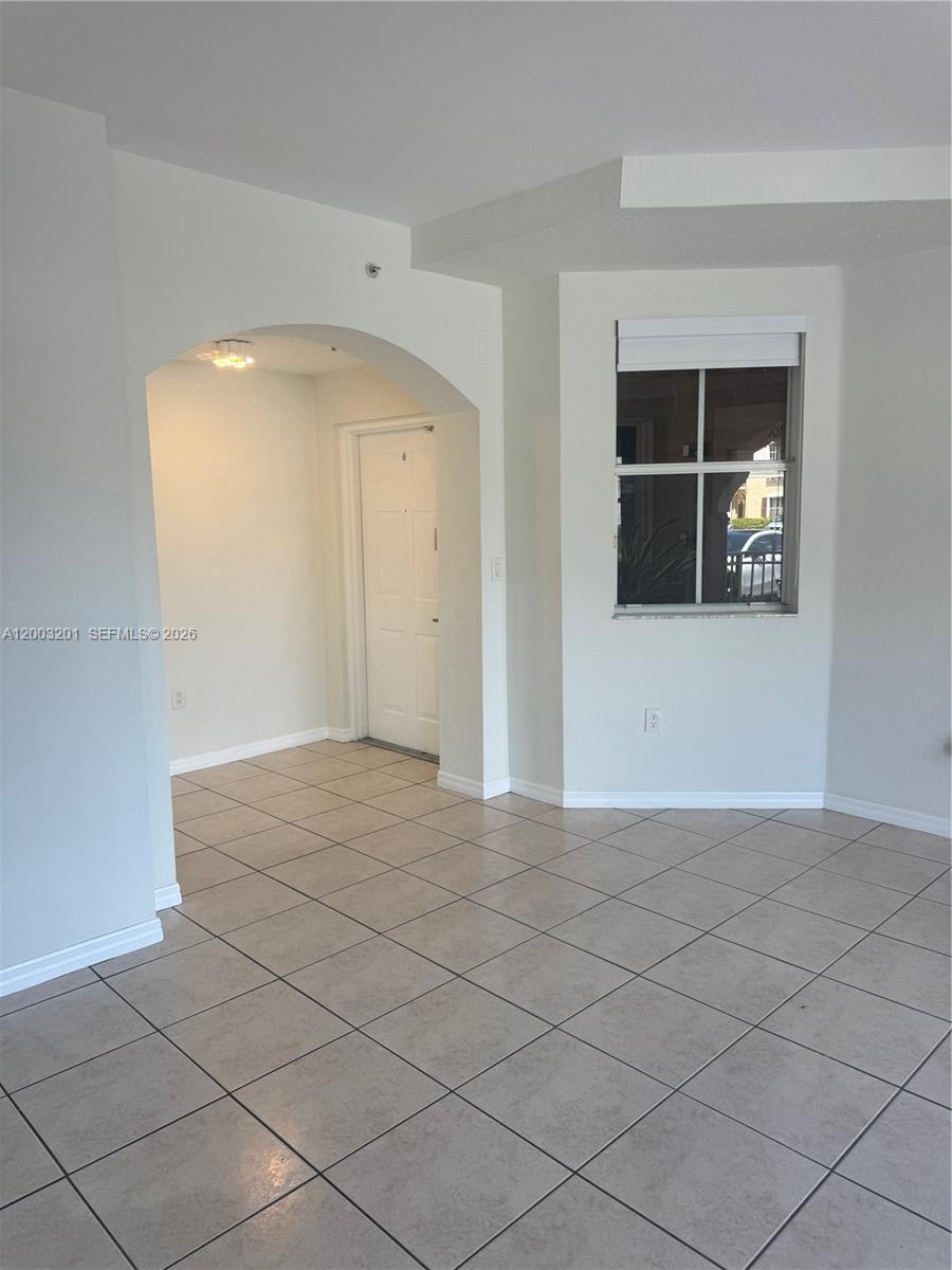 An interior room features light-colored tile flooring, an arched entryway, and a single window — 8826 W Flagler St # 102, Miami FL 33174, MIAMI, FL
