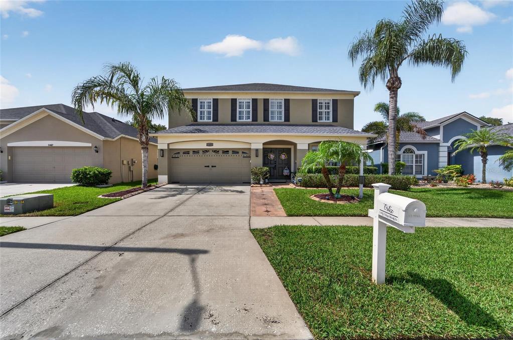 A two-story suburban house with a concrete driveway, a front lawn, and a mailbox — 11405 VILLAGE BROOK DRIVE, RIVERVIEW, FL