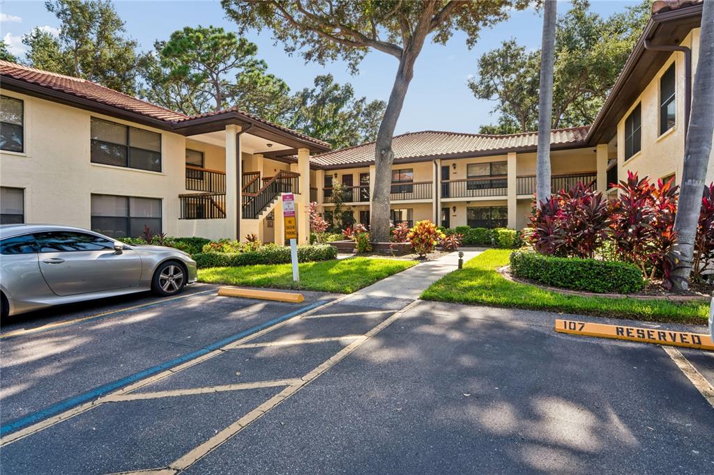 An exterior view of a two-story apartment building with a parking lot in the foreground — 110 HAMMOCK PINE BOULEVARD, CLEARWATER, FL