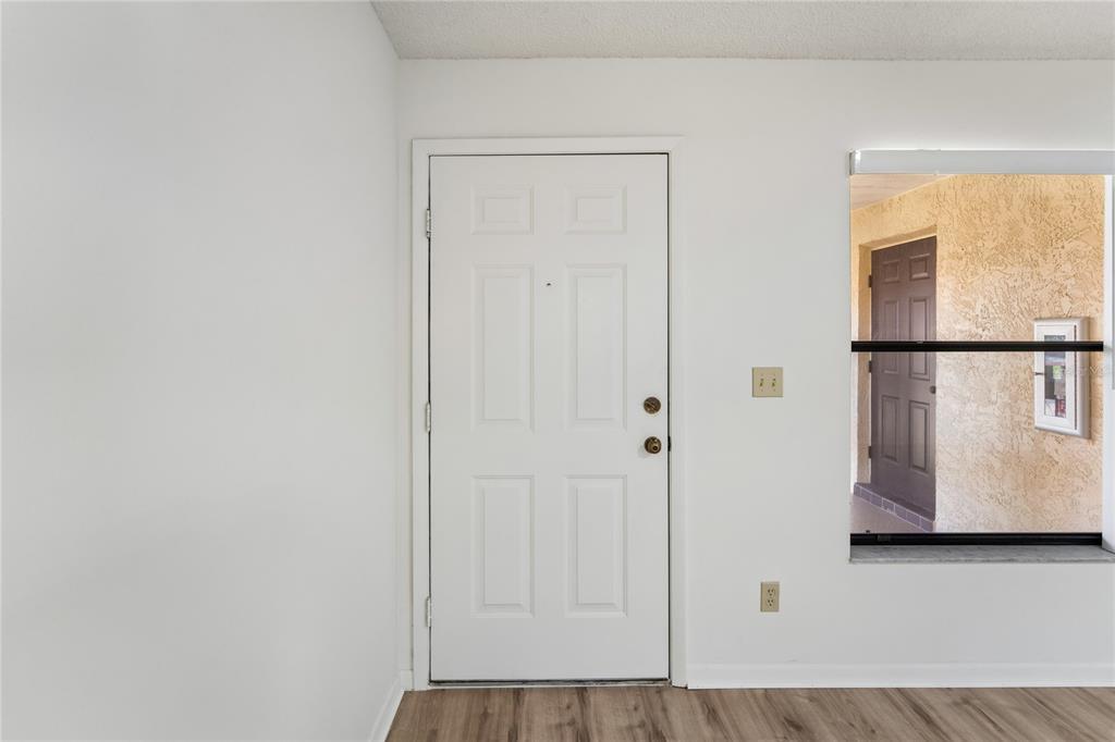 A white interior door and a window looking out to an exterior hallway — 110 HAMMOCK PINE BOULEVARD, CLEARWATER, FL