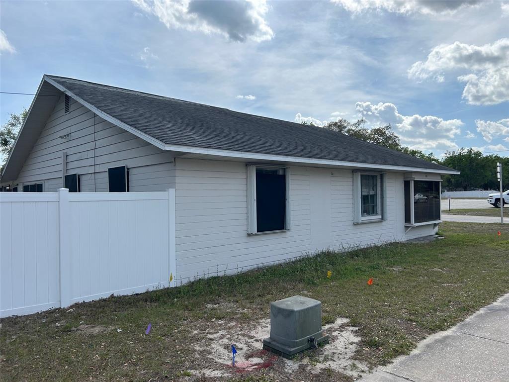 A single-story house with white horizontal siding and a white vinyl fence in the yard — 2405 SOUTH STREET, LEESBURG, FL