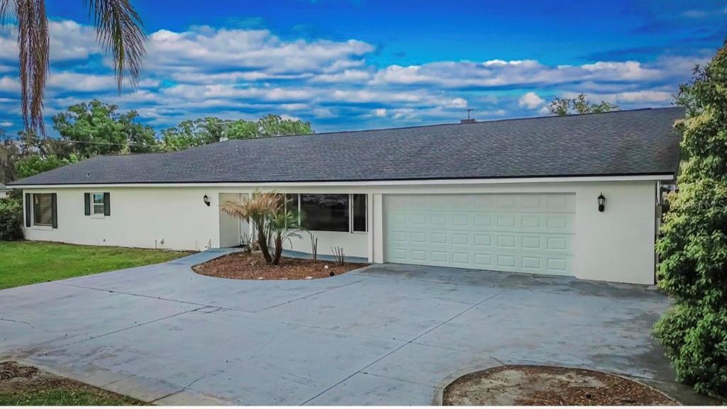 A single-story house with a white exterior, a dark shingled roof, and a concrete driveway — 723 W PINEDALE DRIVE, PLANT CITY, FL