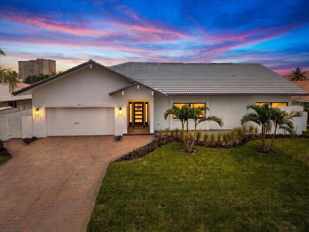 A single-story white house with a gray tiled roof, a garage, and palm trees — 4973 60TH AVENUE S, ST PETERSBURG, FL