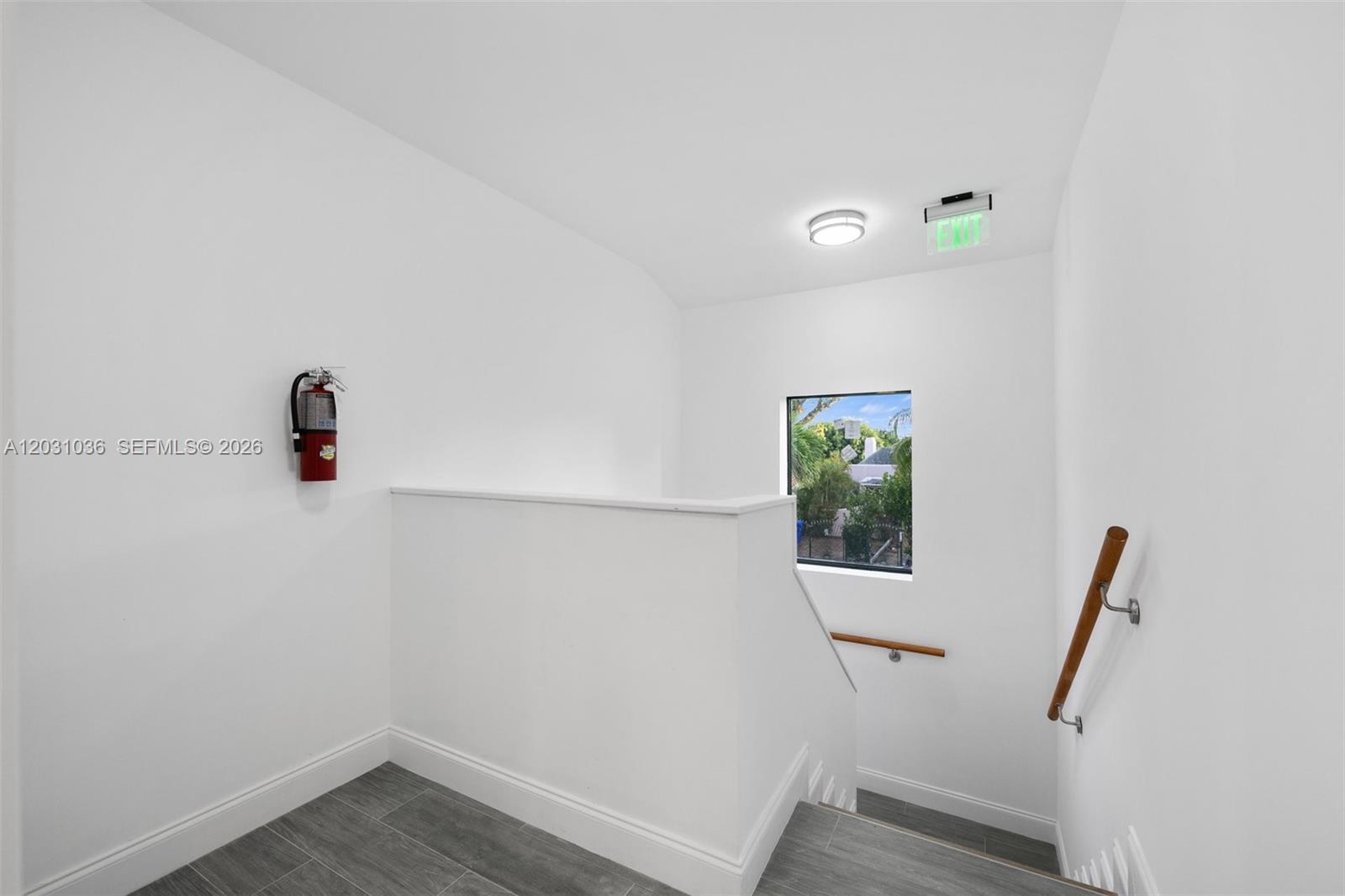 A staircase landing features white walls, gray tile flooring, a fire extinguisher, and a window — 1721 SW 13th St # 4, Miami FL 33145, MIAMI, FL