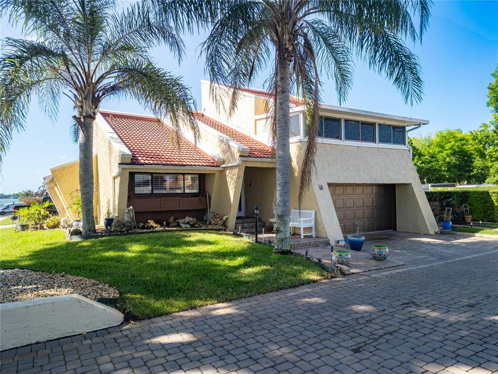 A two-story house with a tiled roof, stucco exterior, and a paved driveway — 4 CASARENA COURT, WINTER HAVEN, FL