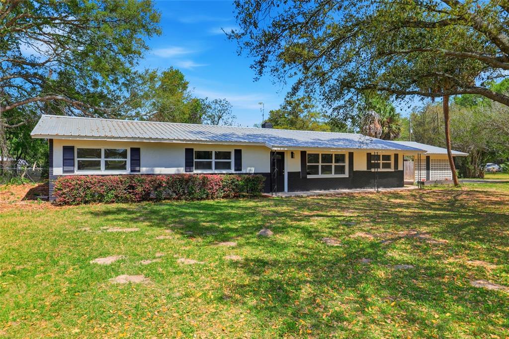 A single-story house with a metal roof, white siding, and black brick accents — 980 SW 105TH STREET, TRENTON, FL