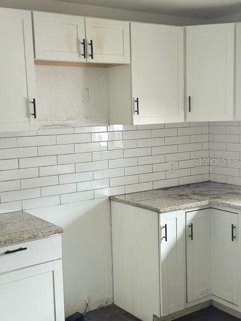 A kitchen features white shaker-style cabinets, granite countertops, and a white subway tile backsplash — 1717 PROVIDENCE BOULEVARD, DELTONA, FL
