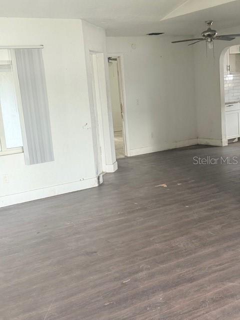 An interior view shows a room with gray wood-look flooring and a ceiling fan — 1717 PROVIDENCE BOULEVARD, DELTONA, FL
