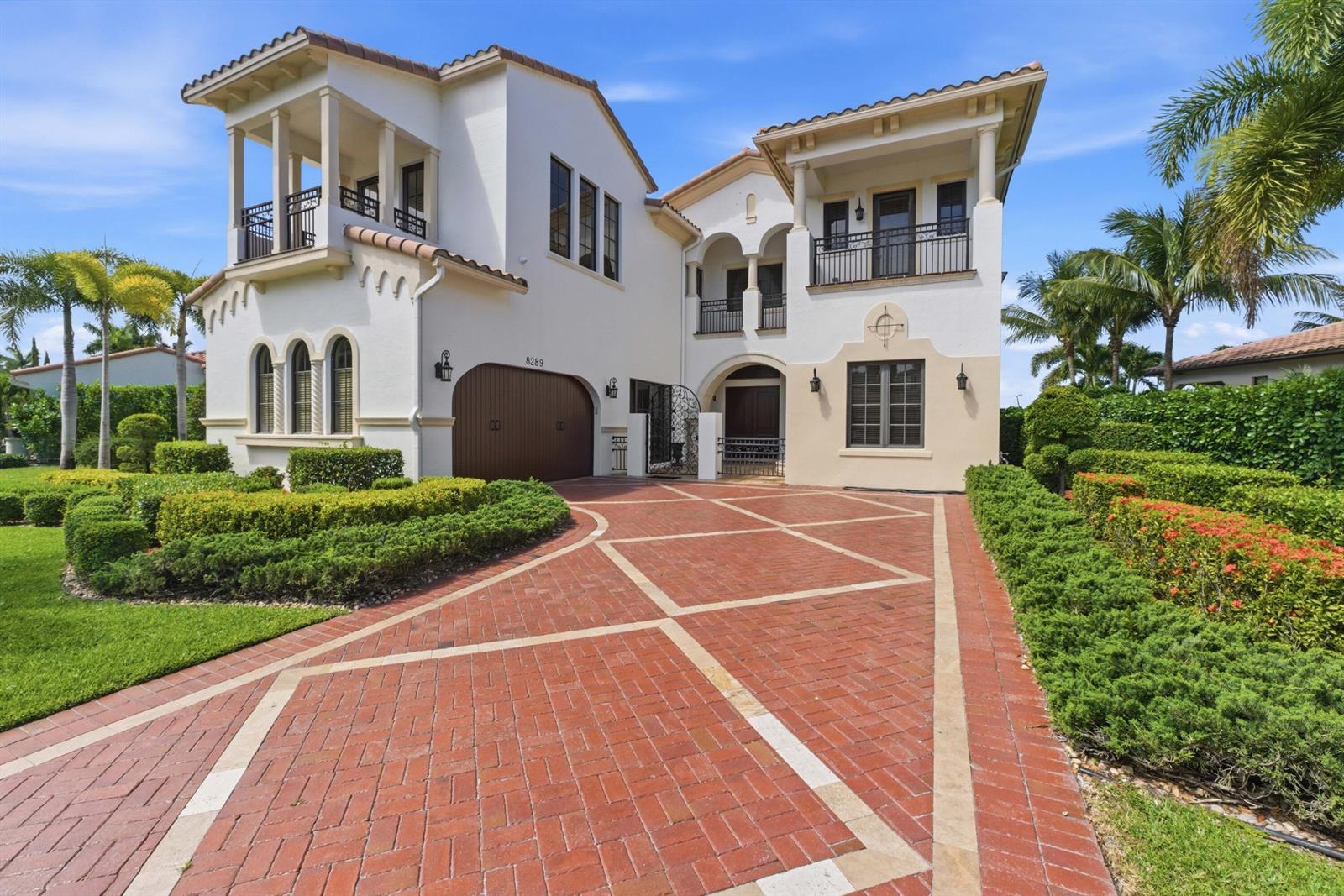 A two-story Mediterranean-style house with a brick driveway and manicured hedges — 8289 Emerald Avenue, Parkland FL 33076, PARKLAND, FL